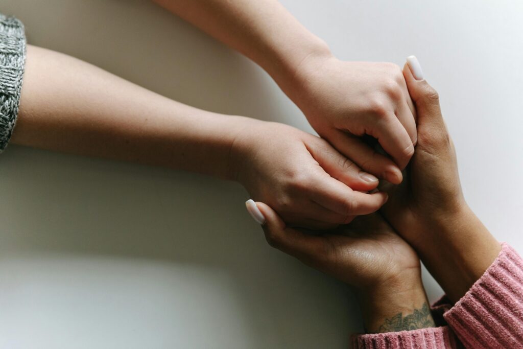 Close-up of diverse hands holding, symbolizing care, support, and friendship.